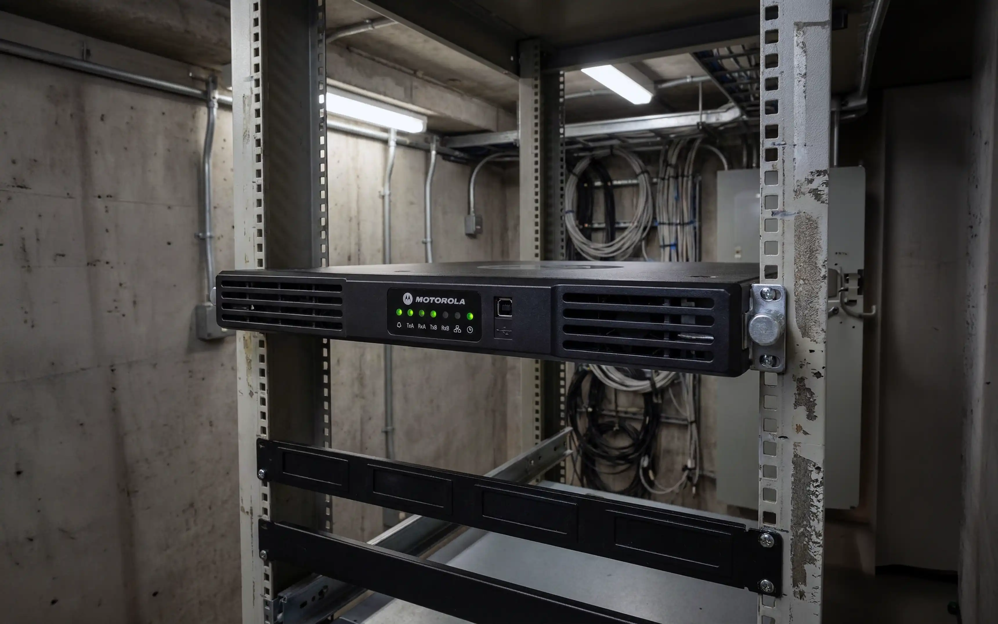 Bild på en Motorola SLR5500 repeater installerad i ett äldre teknikrum under jord.